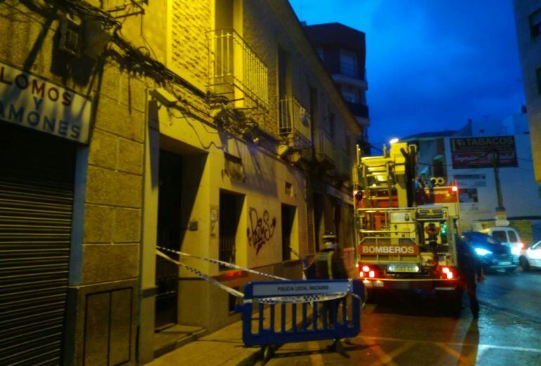 Bomberos del CEIS y la Policía local de Mazarrón actúan en una fachada, saneando un balcón.
