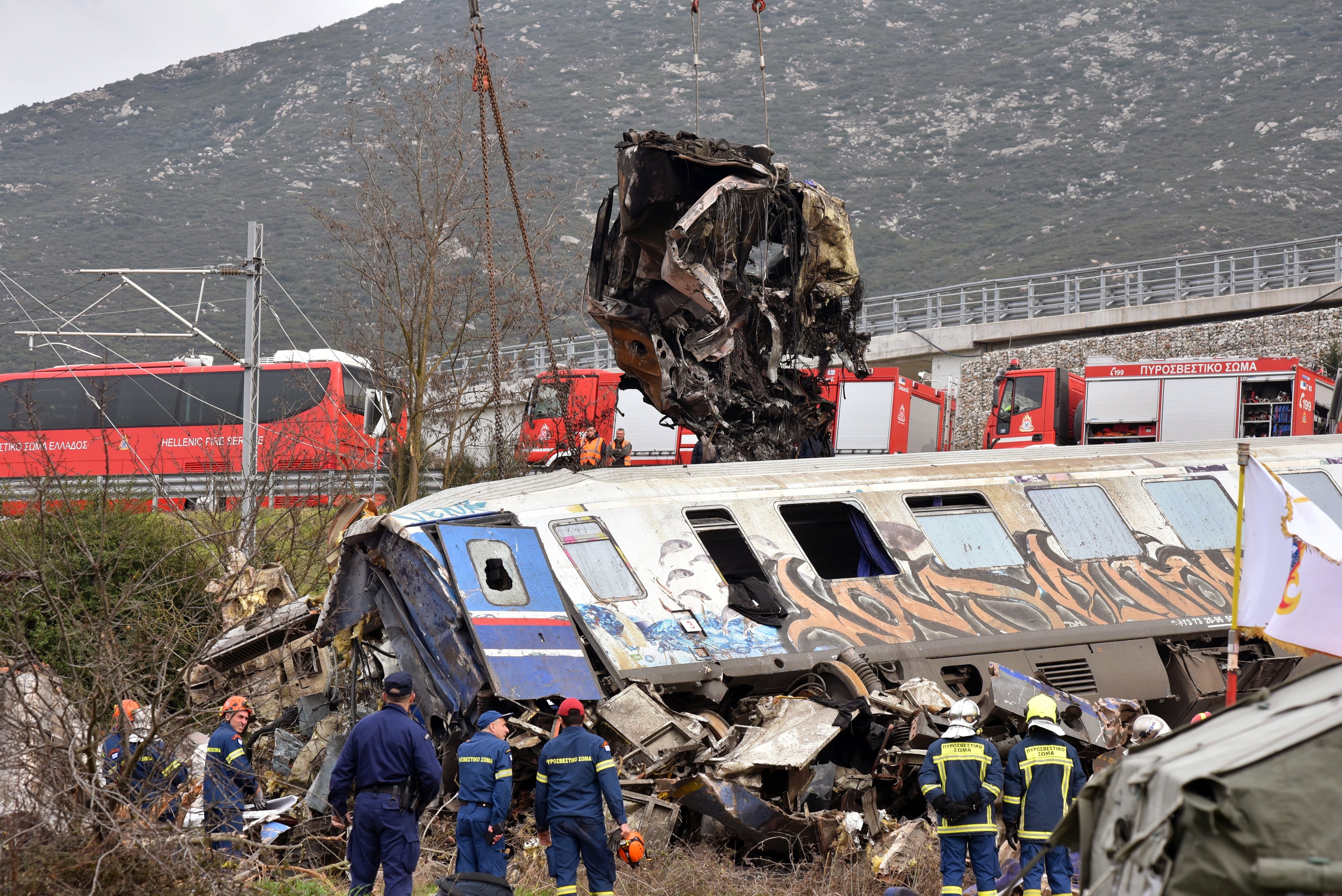 Efectivos de salvamento manejan unos vehículos grúa para retirar piezas de los vagones de tren dañados tras una colisión cerca de la ciudad de Larissa, Grecia, el pasado 1 de marzo.