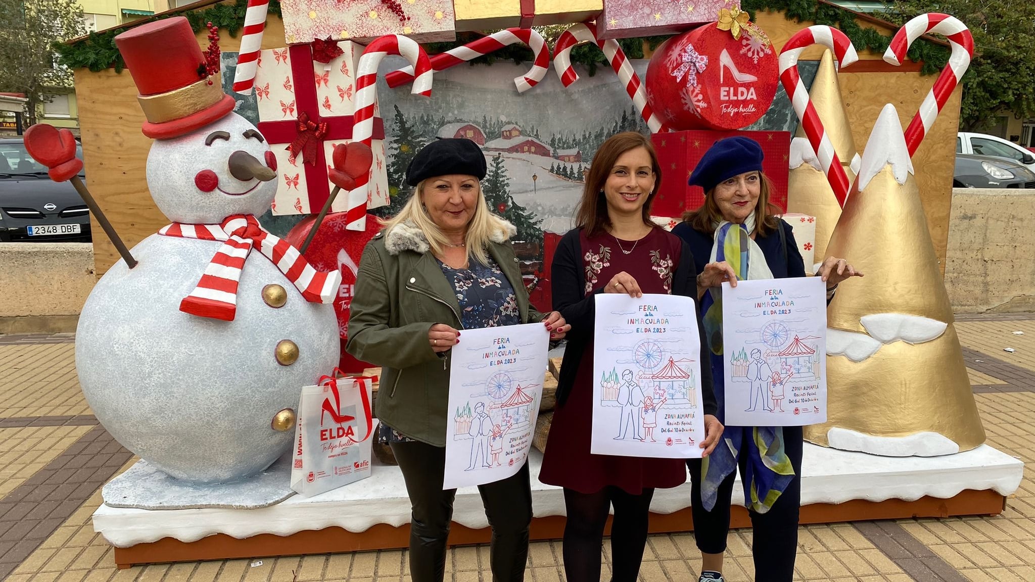 La presidenta de la Asociación de Artesanos de Elda, Sol Pérez, junto a la concejala de Comercio y Mercados de Elda, Silvia Ibáñez y la artista que ha diseñado el cartel, Carmen Castaño