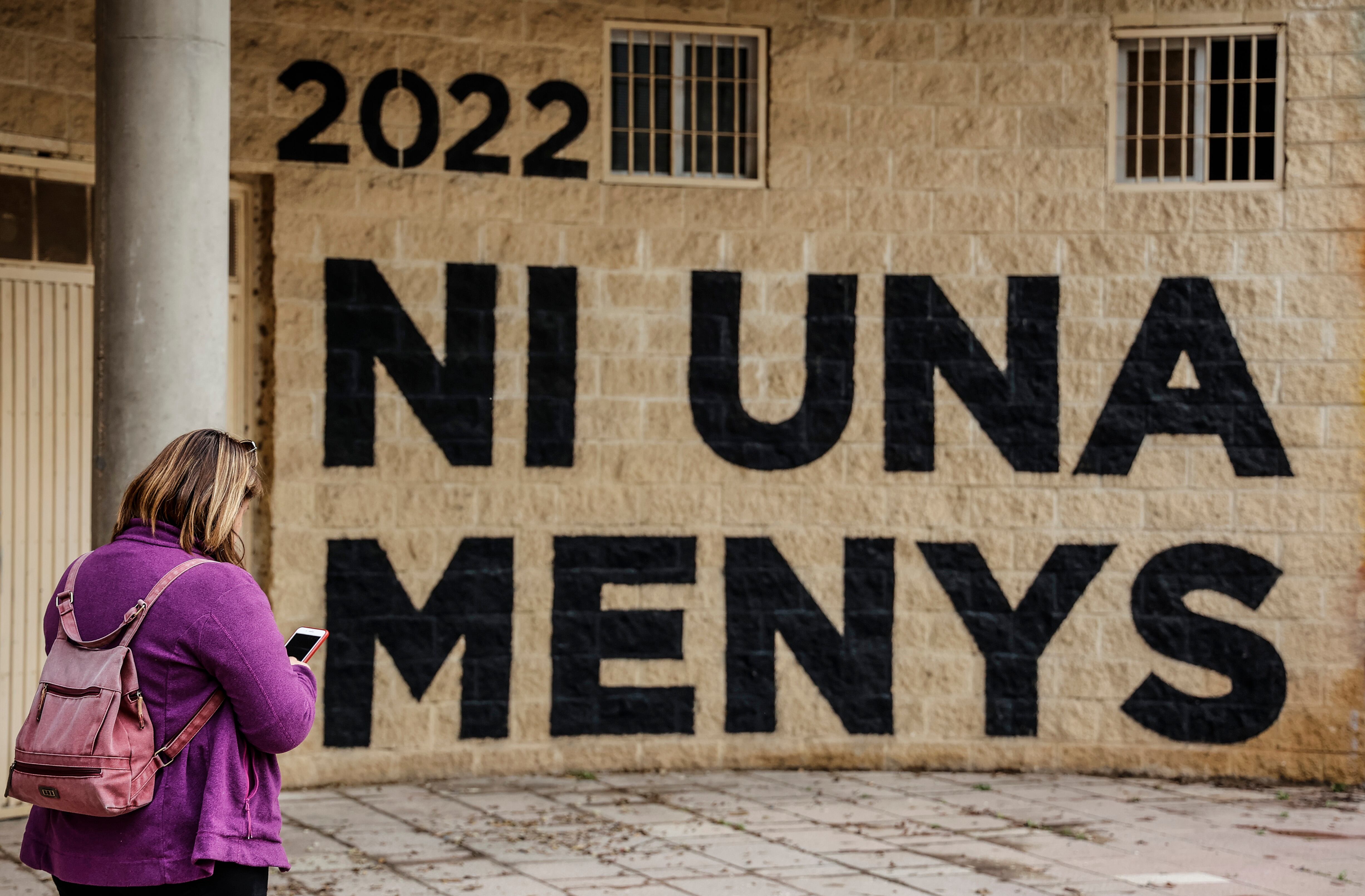 Una mujer pasea frente a un mural de &#039;Ni una menos&#039; pintado en el jardín del Turia de València