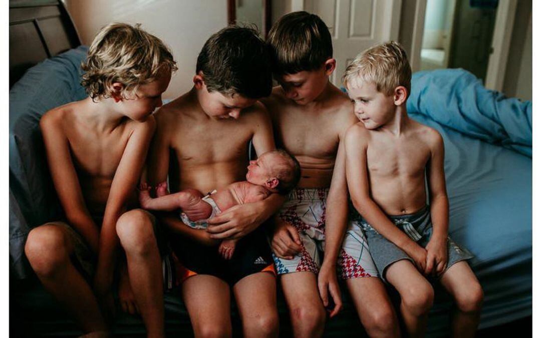 Unos niños cuidan a un recién nacido. fotografía premiada en un concurso