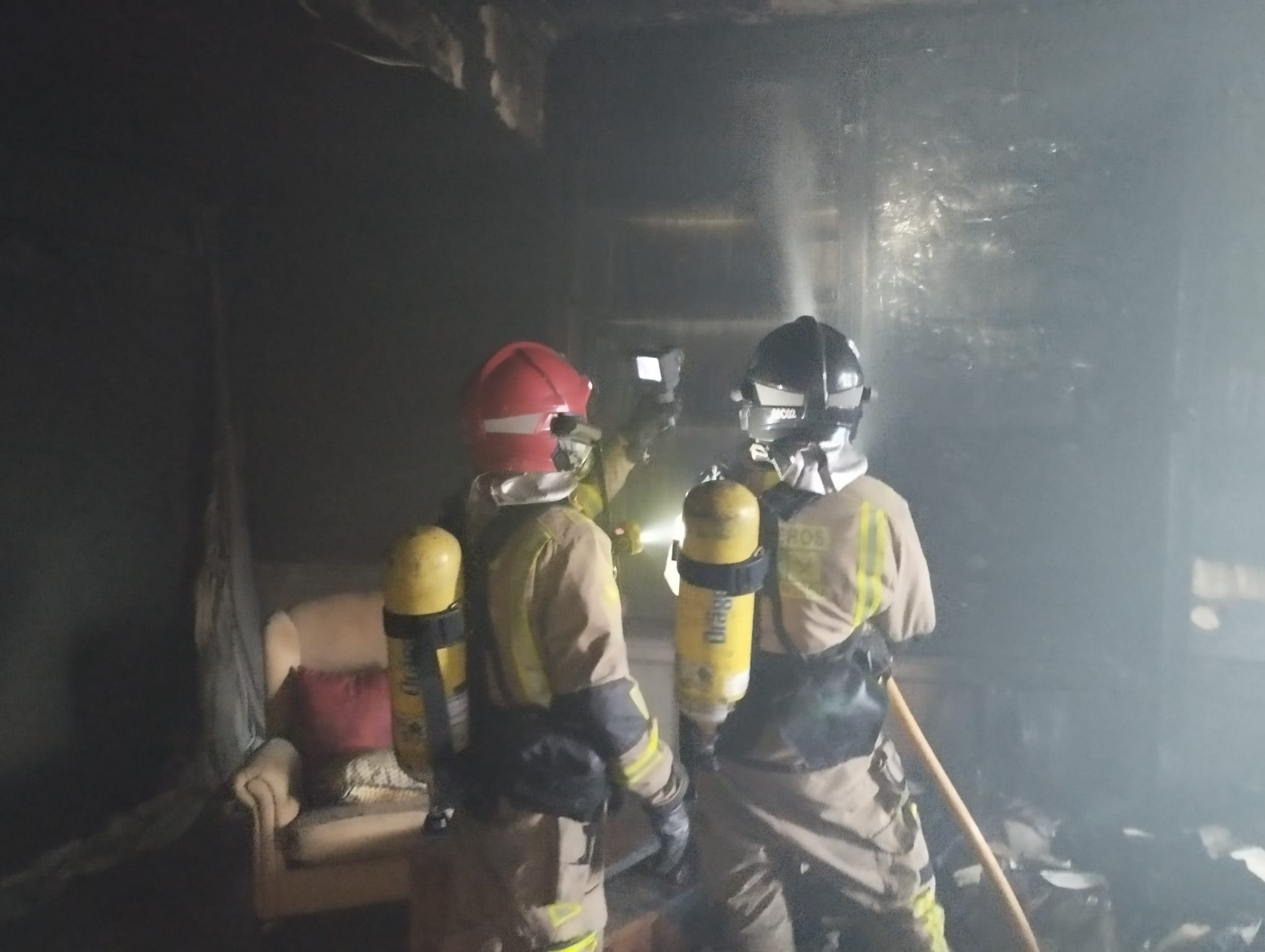 Bomberos en el interior de la vivienda incendiada en Las Torres de Cotillas