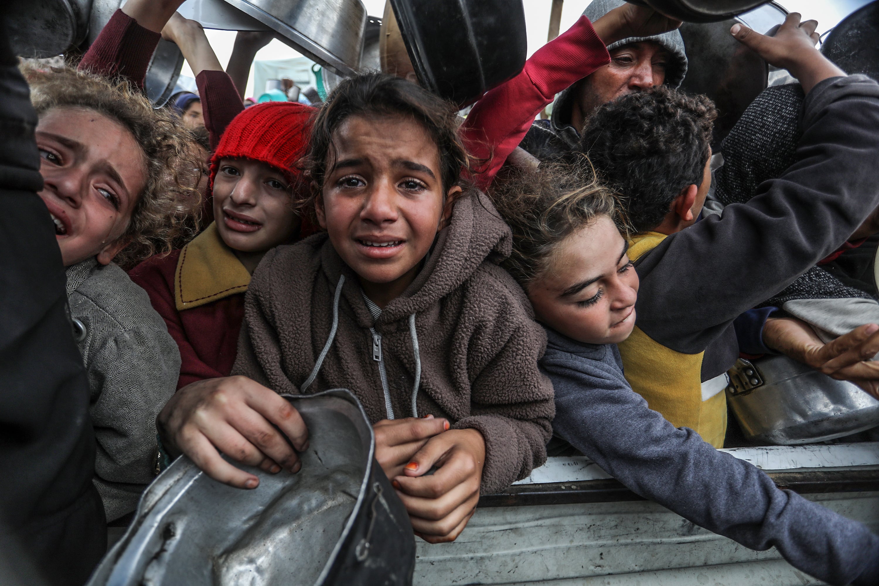 Niños se amontonan para recibir ayuda humanitaria en la Franja de Gaza.
