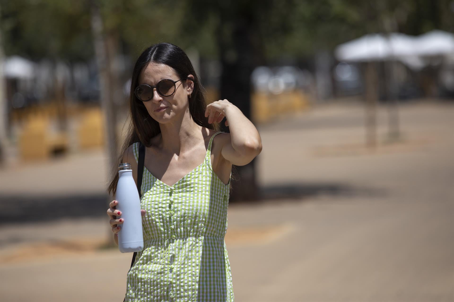 Una mujer con gafas de sol y botella de agua