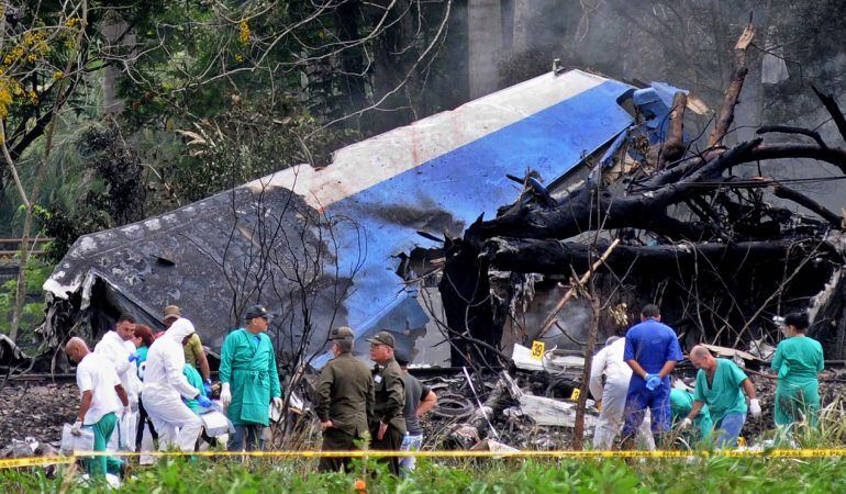 Policías y militares trabajan entre los restos del avión Boeing-737 que se estrelló este viernes.