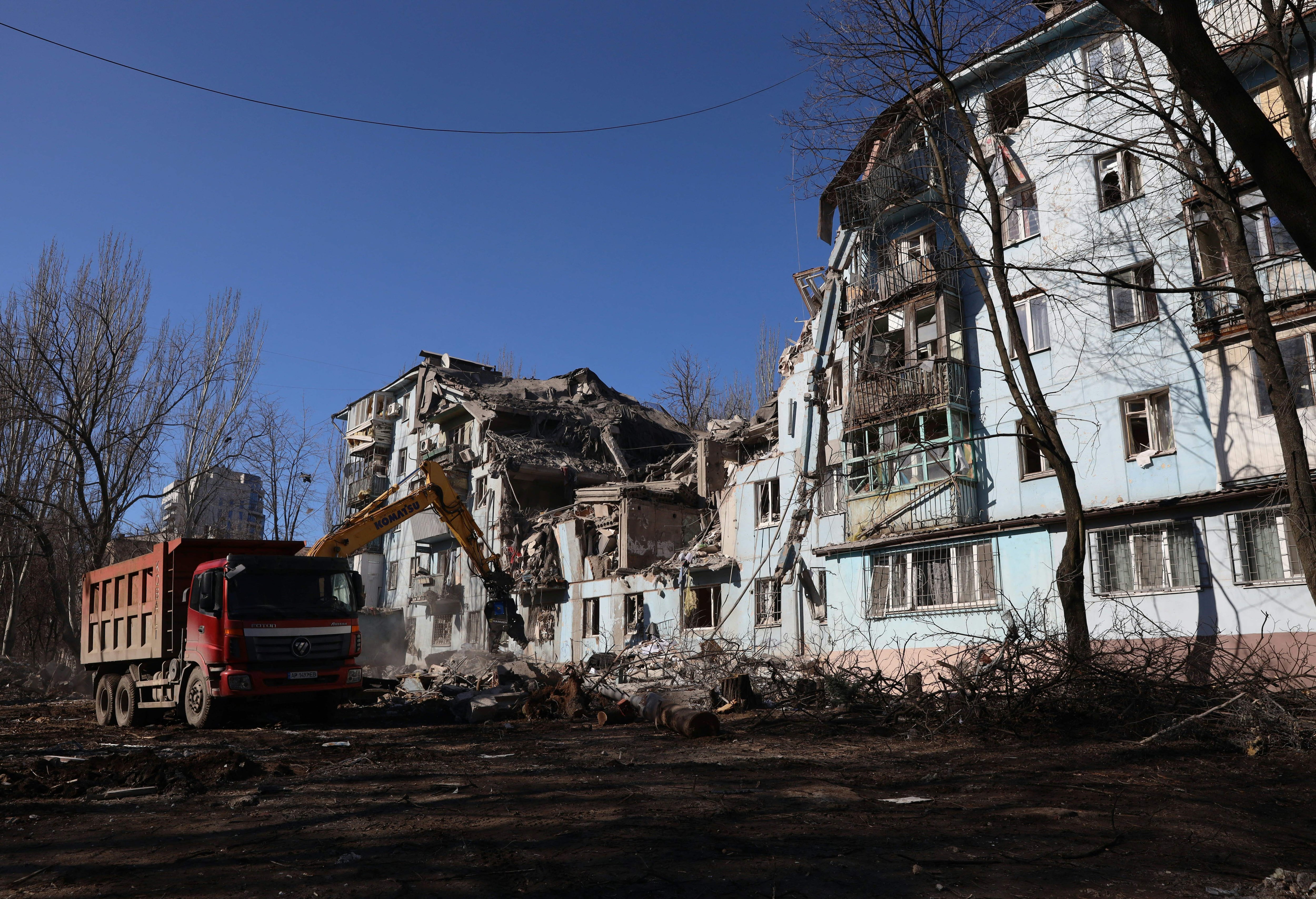 Los equipos de rescate ucranianos trabajan con una excavadora en un edificio residencial de cinco pisos destruido tras un ataque con misiles en Zaporiyia este jueves