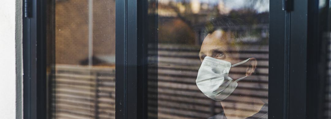 Hombre mira por la ventana durante la crisis sanitaria del Covid 19