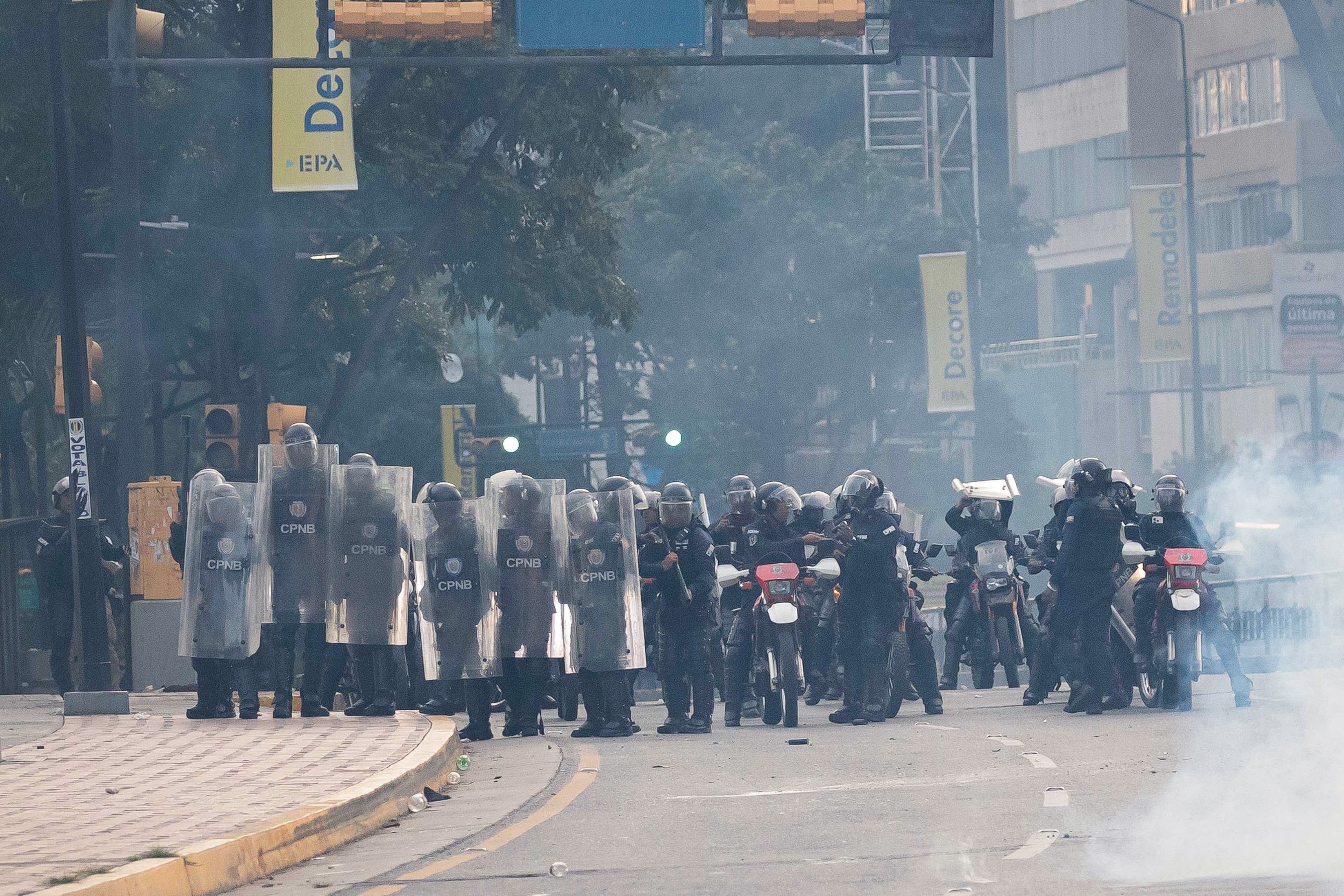 Integrantes de la Policía Nacional Bolivariana (PNB) enfrentan a manifestantes opositores este lunes, durante una protesta contra de los resultados de las elecciones presidenciales, en Caracas (Venezuela).