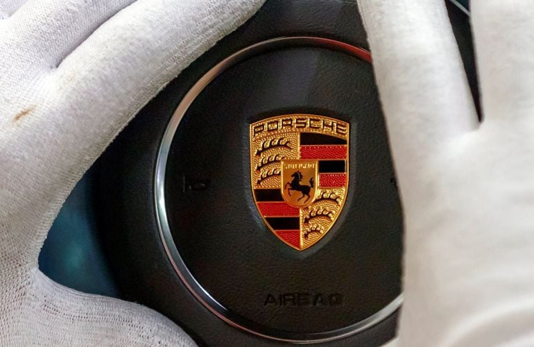 Un operario comprueba un logotipo en una planta de fabricación de Porsche en Stuttgart