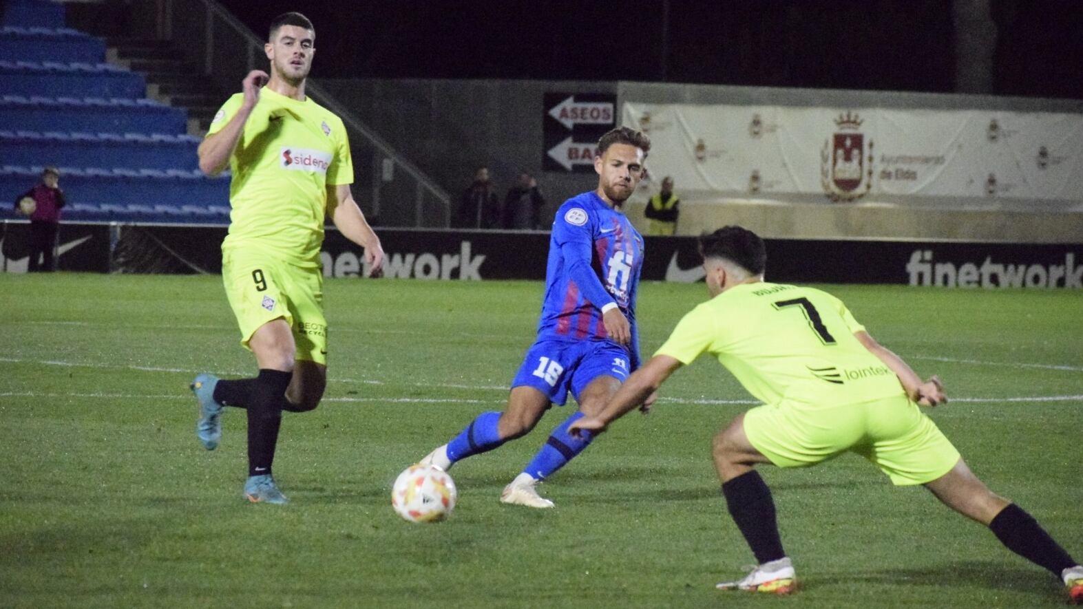 Diego González centra entre dos rivales del equipo vizcaíno