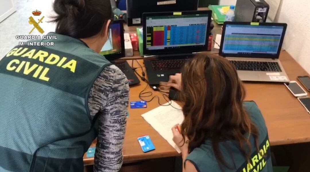 Agentes de la Guardia Civil examinando algunas de las tarjetas.