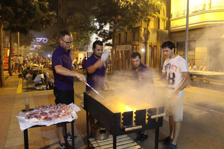 Peñistas preparando las brasas para torrar la carne en el día de la Xulla