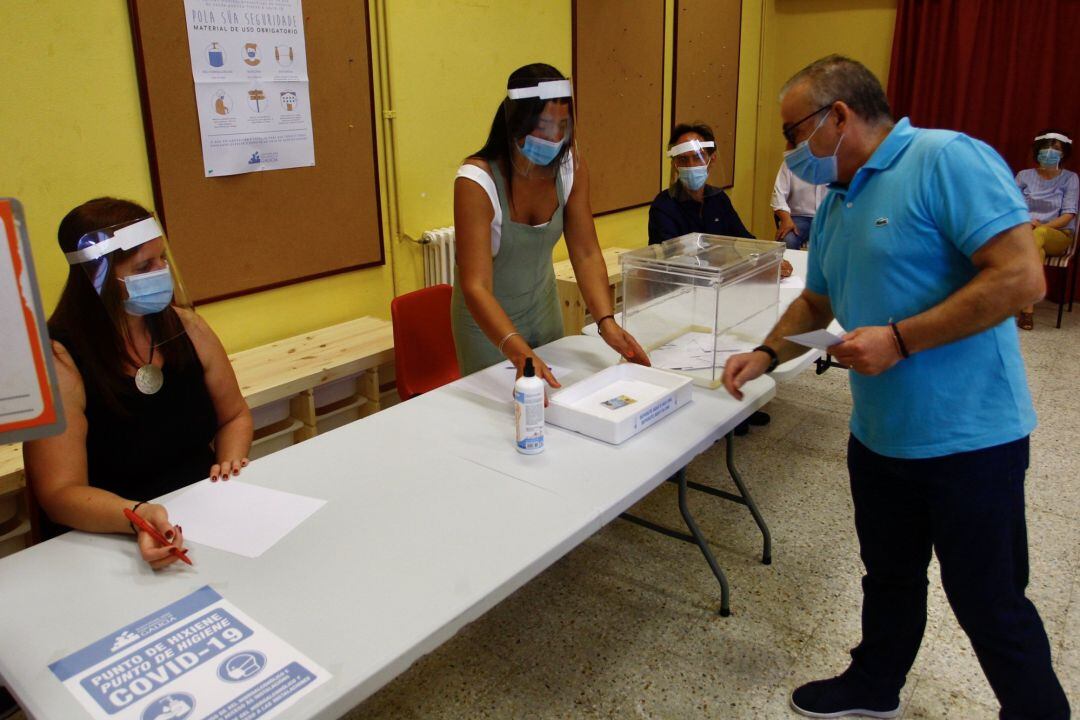 Un ciudadano deposita su voto en la urna durante un ensayo organizado por la Xunta de cara a las elecciones autonómicas del 12 de julio. 
 