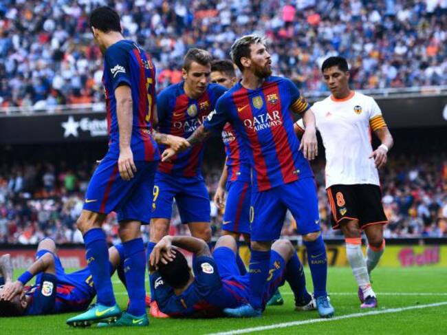 Dos jugadores del Barcelona se duelen en el terreno de juego por el impacto de una botella de plástico y Messi se encara con la afición.