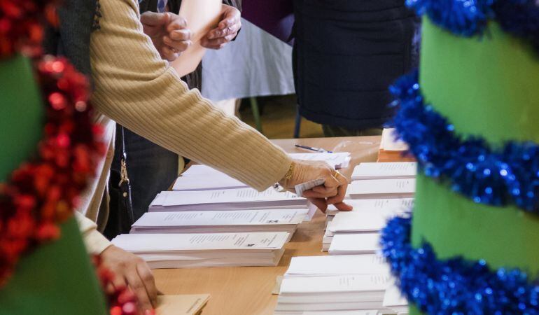 Una mujer elige sus papeletas en un colegio electoral del barrio sevillano de Triana.