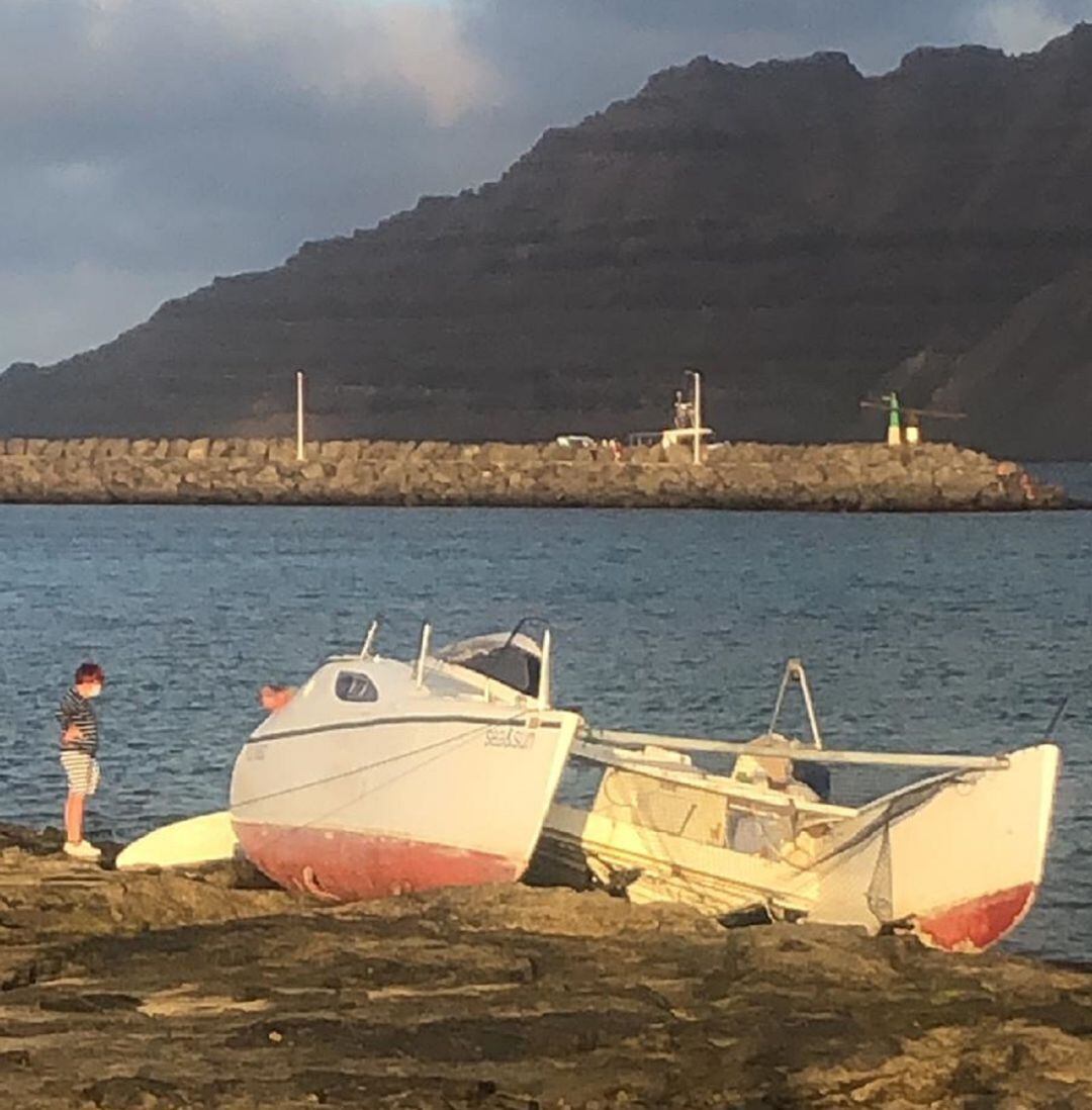 Los propietarios de la embarcación encallada en La Graciosa salvando algunas de las pertenencias del interior.