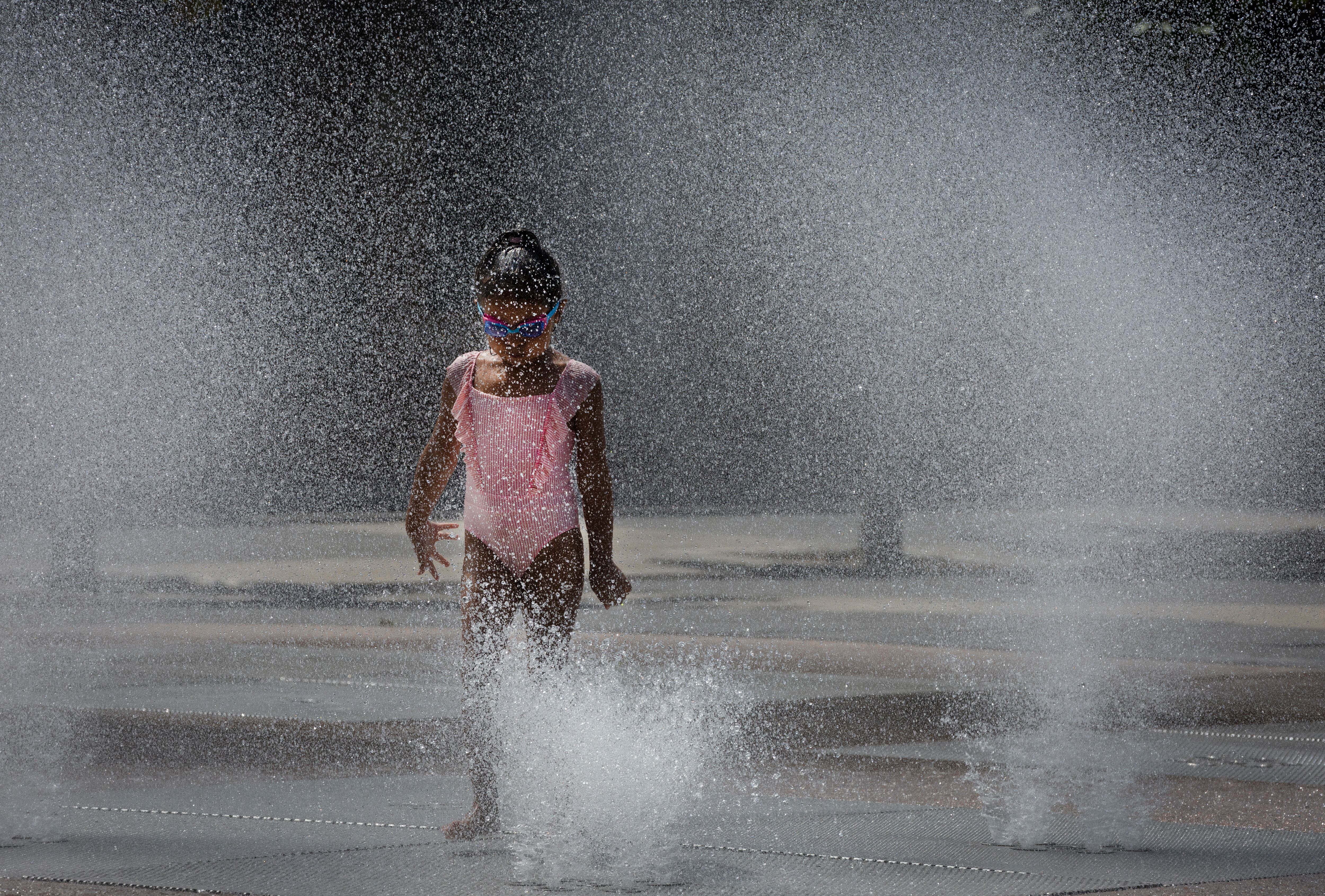 Una niña se refresca en una fuente de Pamplona. EFE/ Villar López