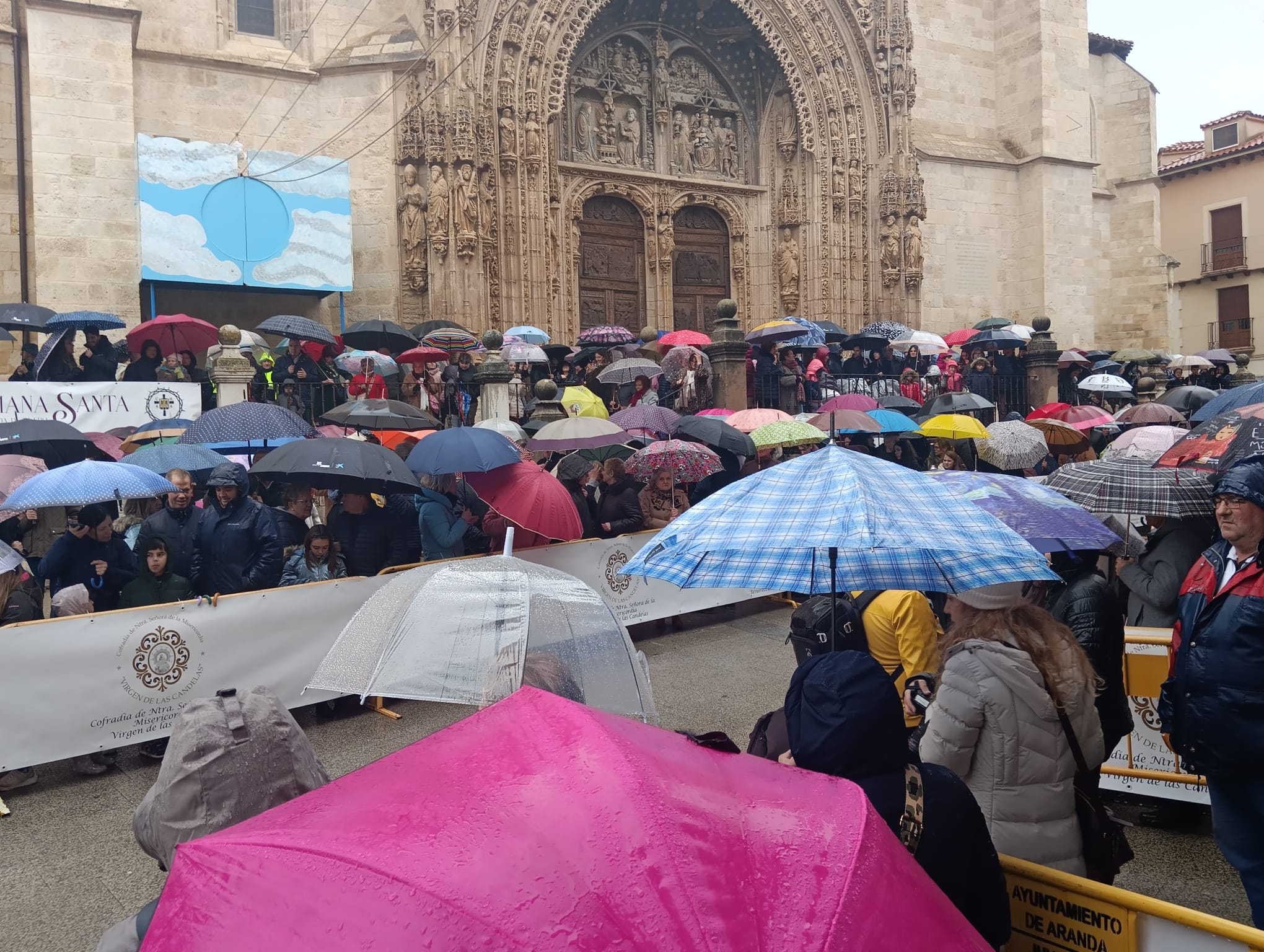 Minutos antes del inicio del acto, el público aguanta bajo la lluvia