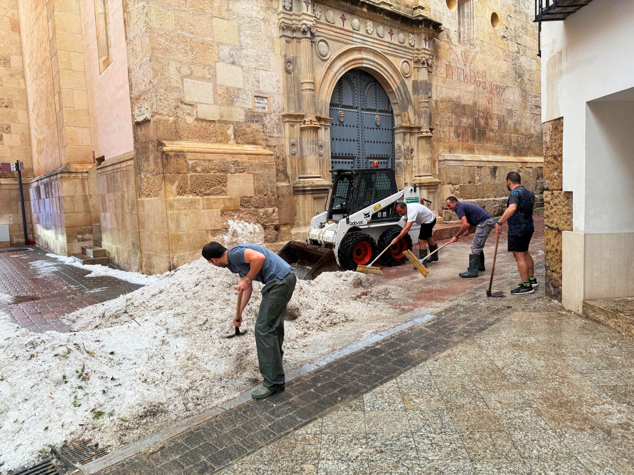 Operarios municipales trabajan en la retirada de granizo en Caravaca de la Cruz a las puertas de la Iglesia del Salvador. Ayto. Caravaca de la Cruz.