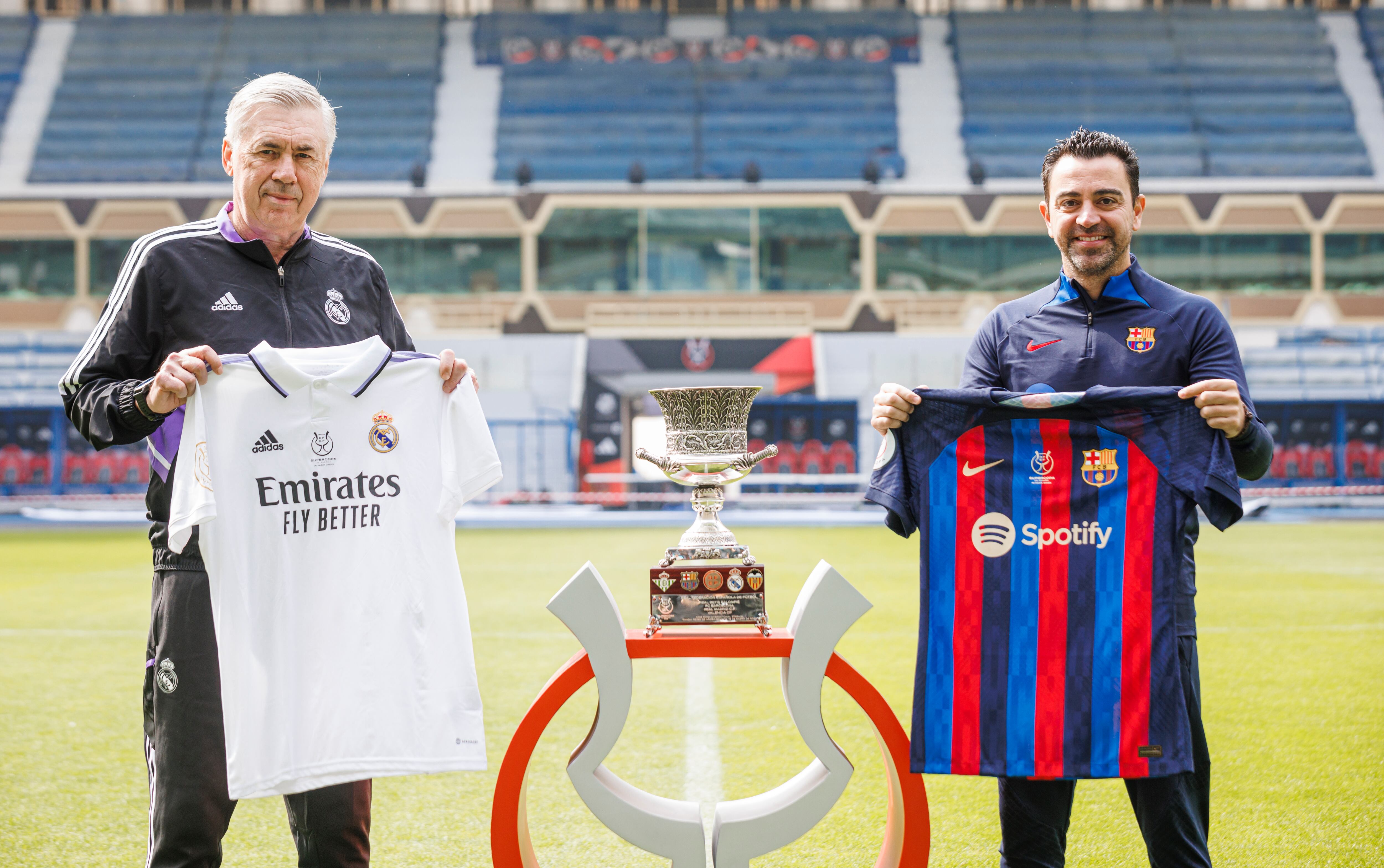 Ancelotti y Xavi posan junto a la Supercopa de España.