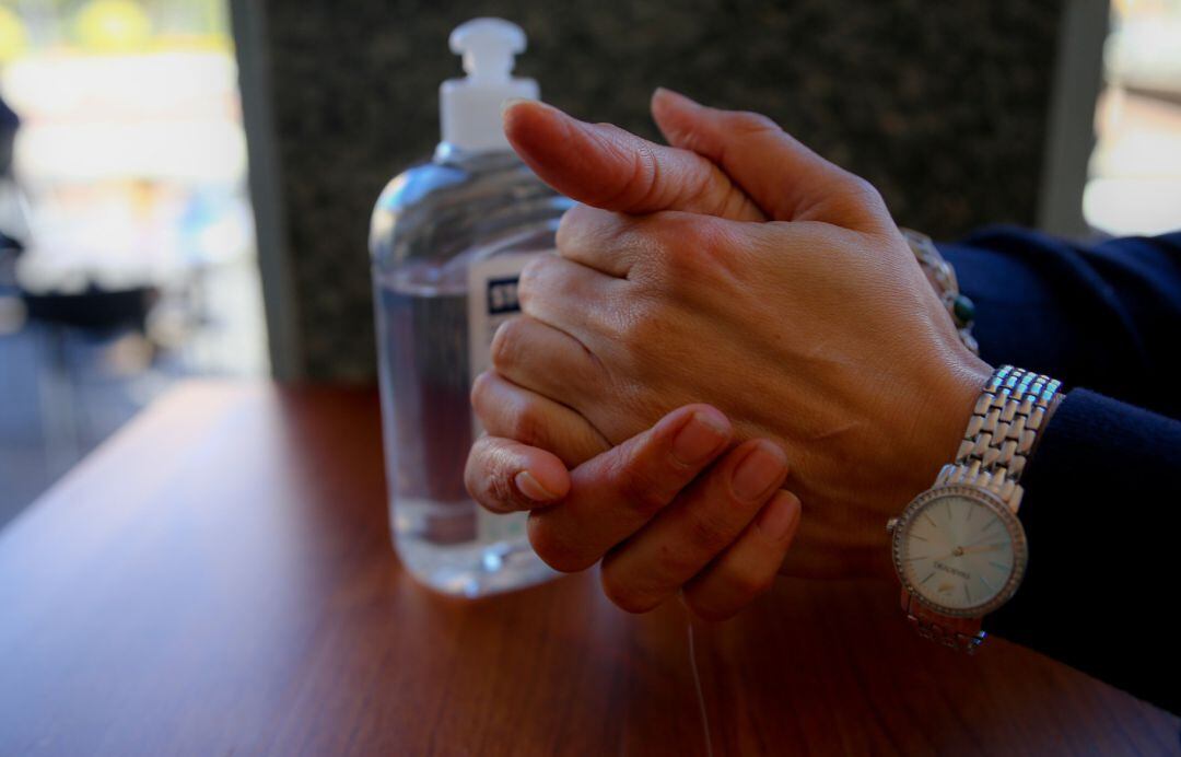 Una persona se desinfecta las manos con gel hidroalcohólico.