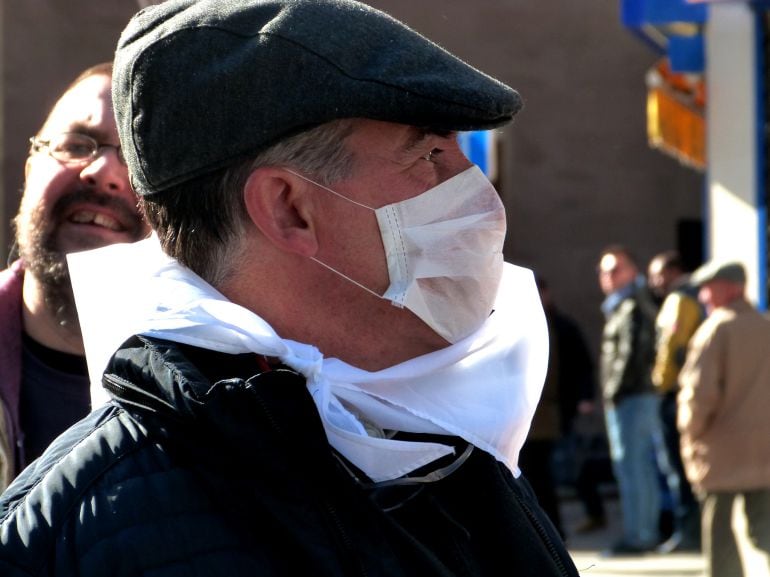 Un hombre durante la manifestación con una mascarilla en la cara.