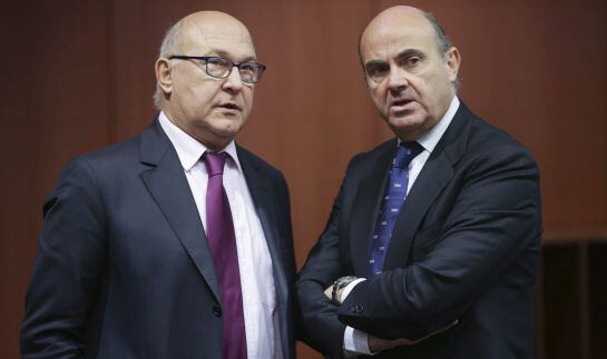 El ministro español de Economía y Competitividad, Luis de Guindos, charla con el ministro de Finanzas francés, Michel Sapin.