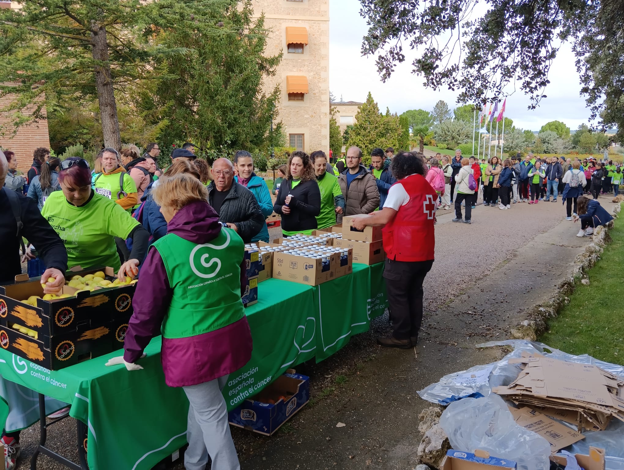 Voluntarios de la AECC y de Cruz Roja reparten el agua y la fruta para repostar