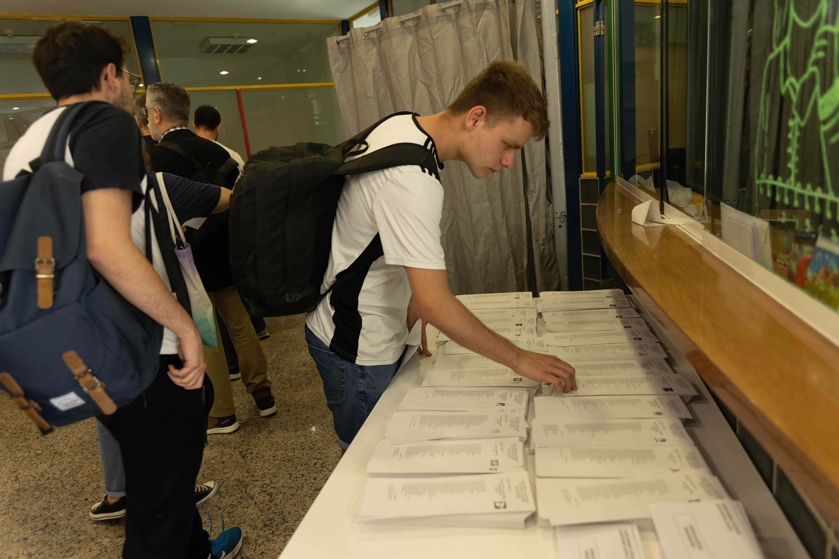 Jóvenes eligiendo la papeleta para votar durante las elecciones municipales y autonómicas del 28 de mayo de 2023.