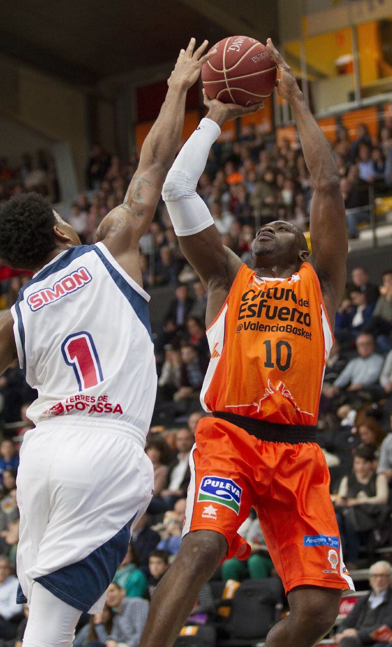 El alero del Valencia Basket Romain Sato (d) lanza a canasta ante el alero estadounidense del ICL Manresa Chase Simon (i), durante el partido de la vigésima tercera jornada de Liga ACB, disputado hoy en el pabellón Fuente de San Luis, en Valencia. 