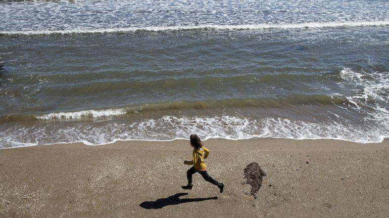 Un niño corre por la playa de la Malvarrosa (Valencia).