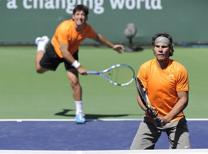 Los tenistas españoles Marc López (i) y Rafael Nadal (d) sirven la bola a los polacos Mariusz Fyrstenberg y Marcin Matkowski hoy, viernes 11 de marzo de 2011, durante el partido del Abierto Paribas en Indian Wells, California (EE.UU.).