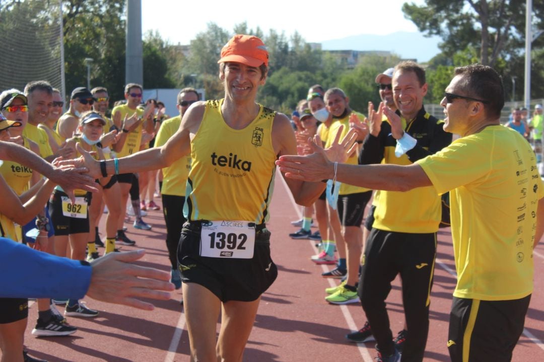 Los compañeros del CA Safor Teika le hacen un pasillo a Tono Boscà tras pasar la meta del medio maratón.