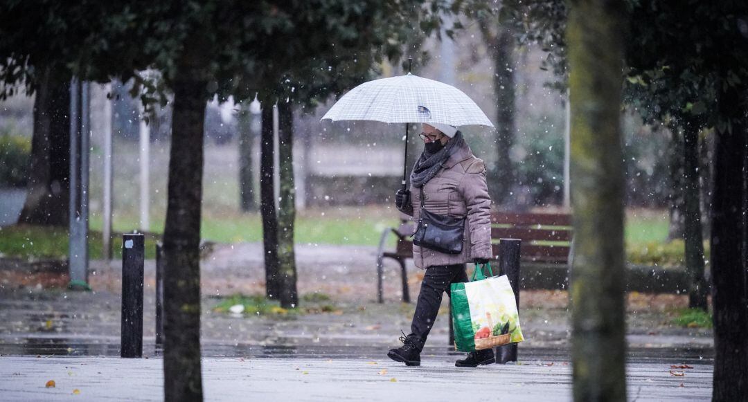 Una mujer camina mientras nieva en Vitoria, 