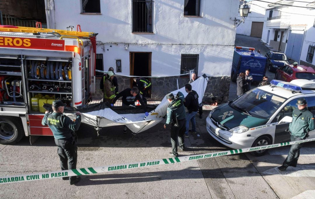 Agentes de bomberos y de la Guardia Civil investigan en una vivienda situada en la calle principal de Dehesas Viejas (Granada).