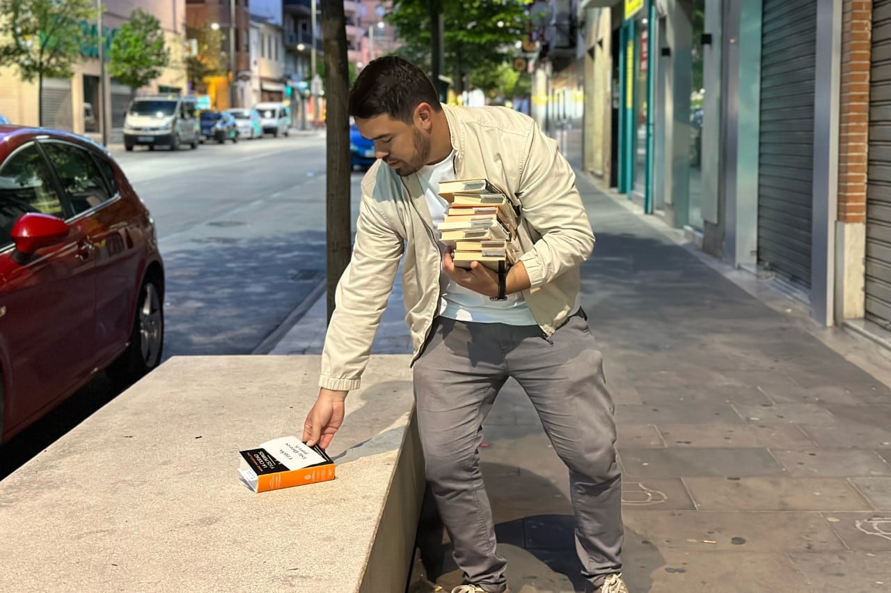 El candidato del PP, colocando libros en los bancos