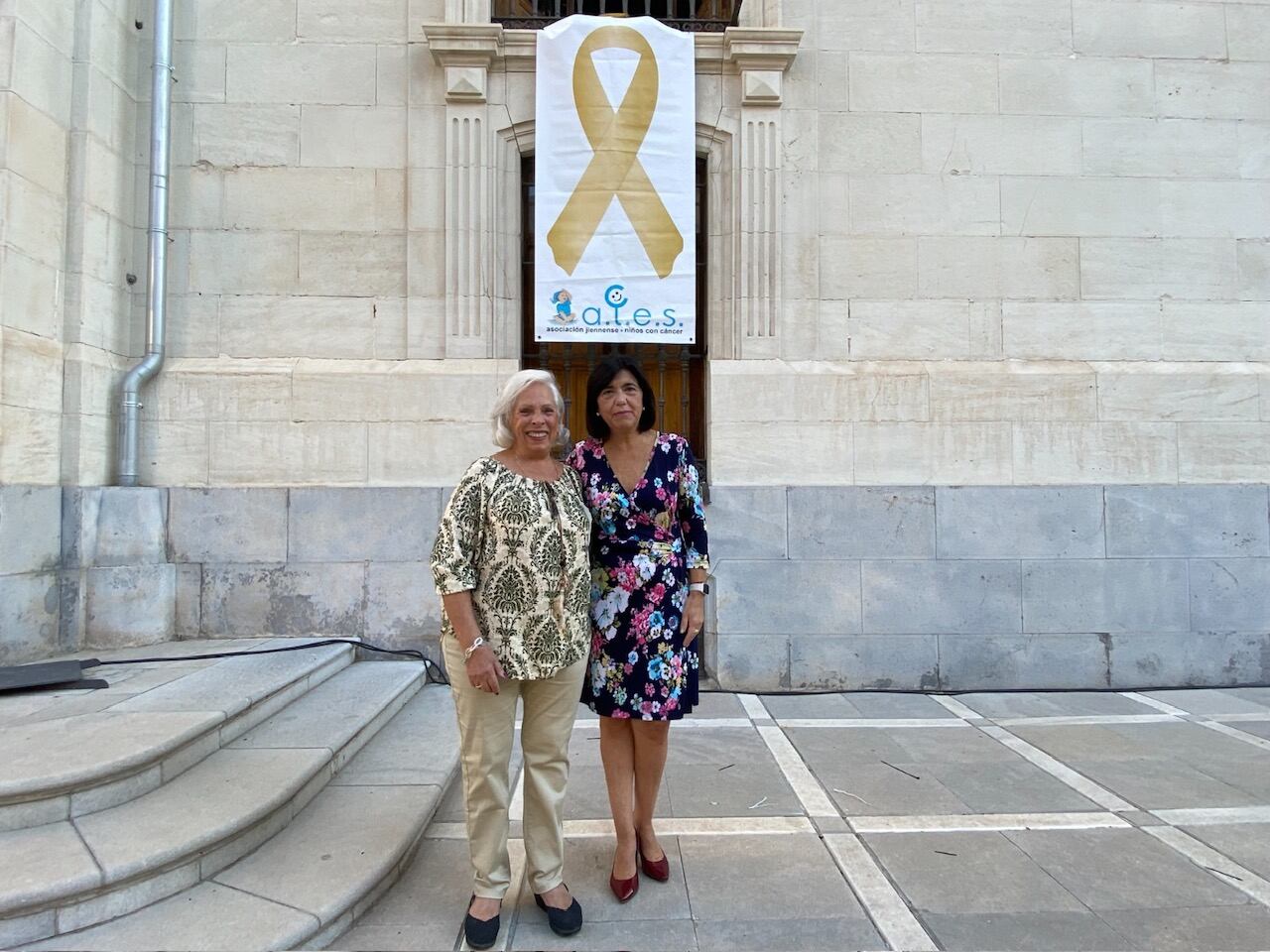 La vicepresidenta de ALES, María Bernal, junto con la diputada de Igualdad y Bienestar Social, Francisca Medina, posan junto al lazo amarillo.