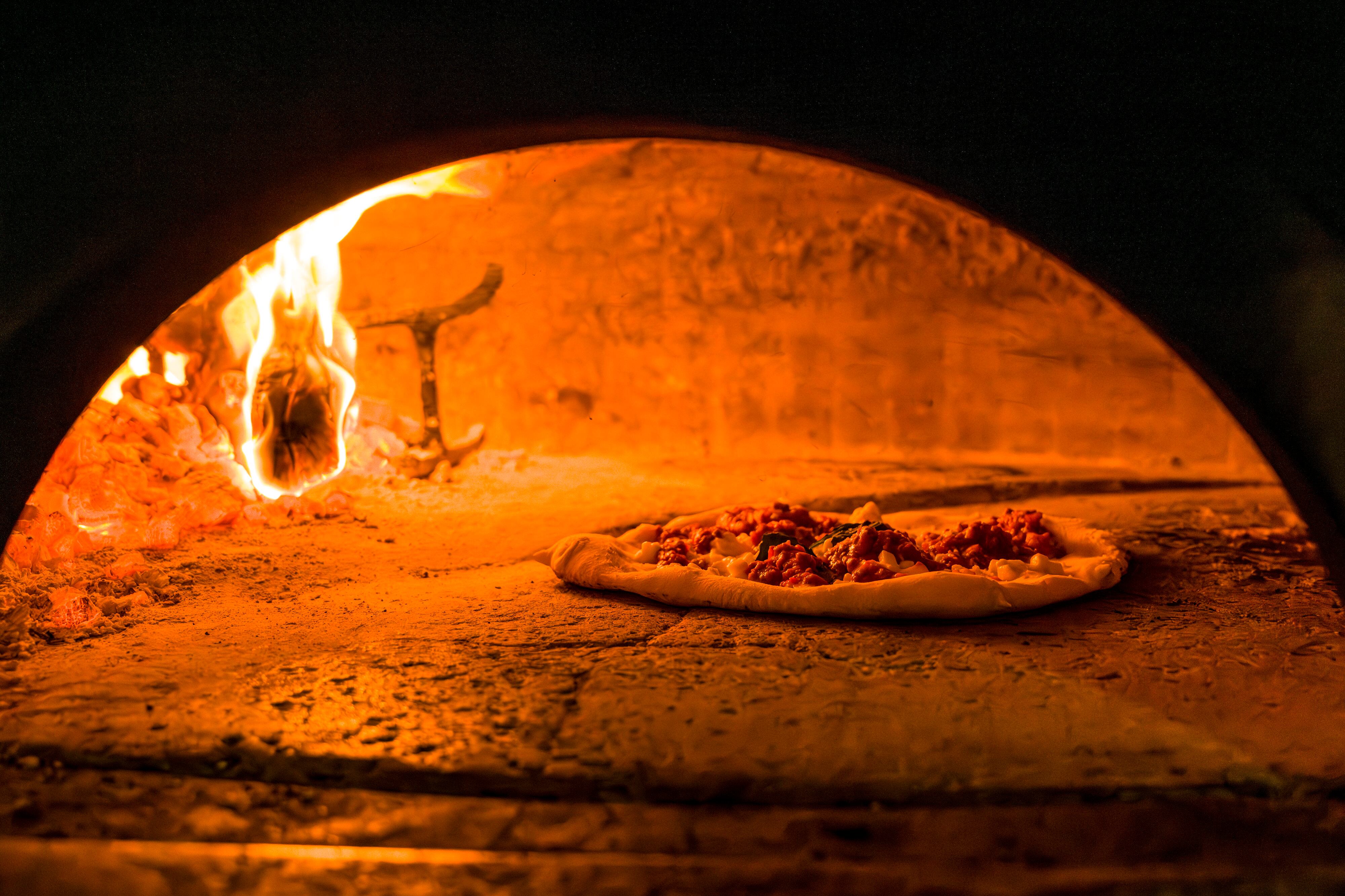 Una pizza se cocina en el horno de piedra de Fuoco Pizzeria Napoletana