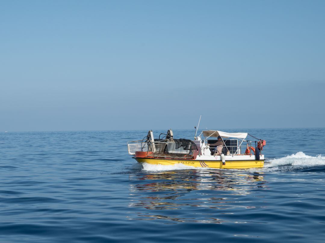 Embarcació fent les tasques de neteja del litoral