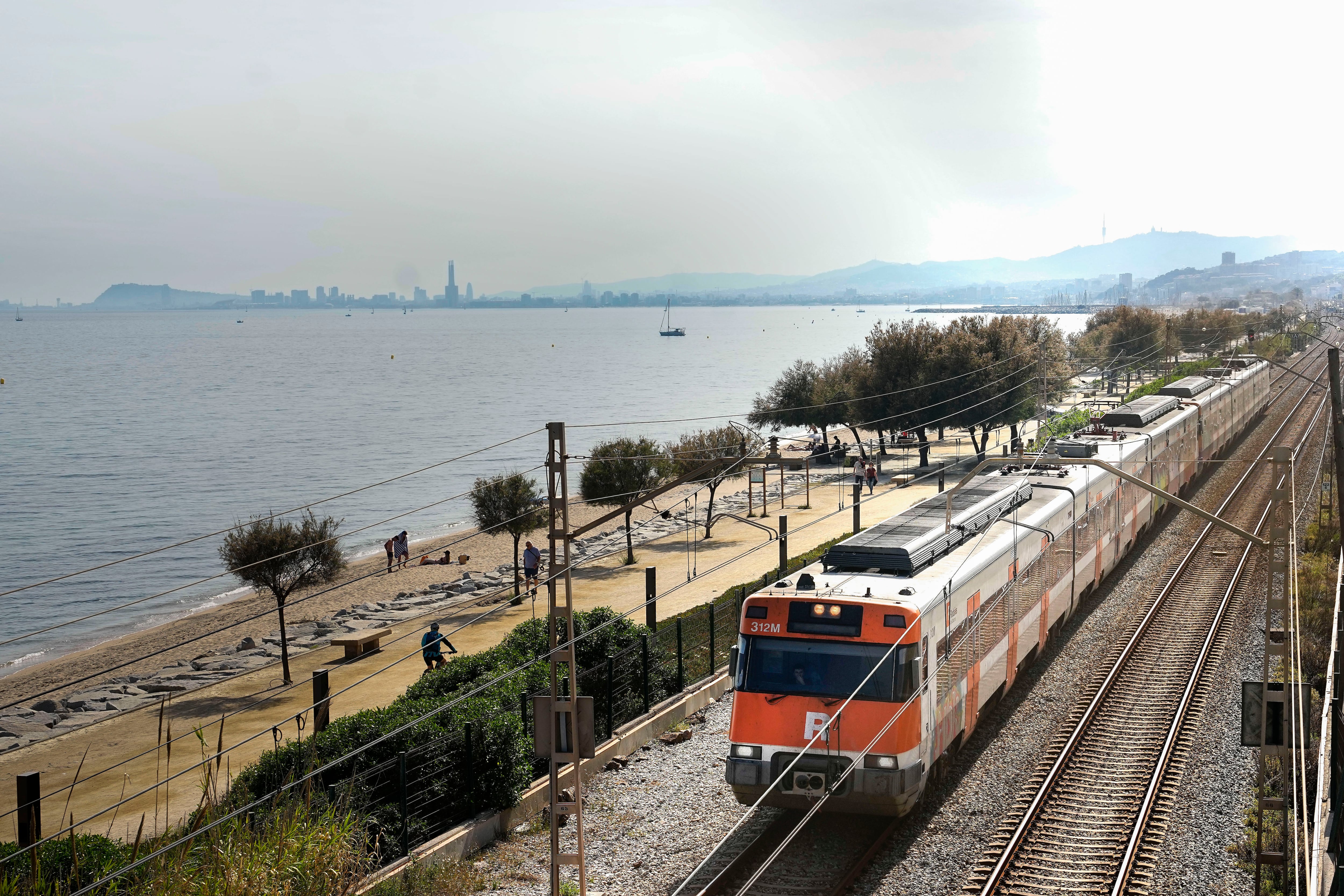 Un robo de cobre ha afectado gravemente a todas las lineas de cercanías (Rodalies) de Catalunya, cortando este domingo completamente las lineas R3 y R8 y parcialmente la R1 (en la imagen con Barcelona al fondo), R2 y R4 el día de las elecciones catalanas.- EFE/ Enric Fontcuberta