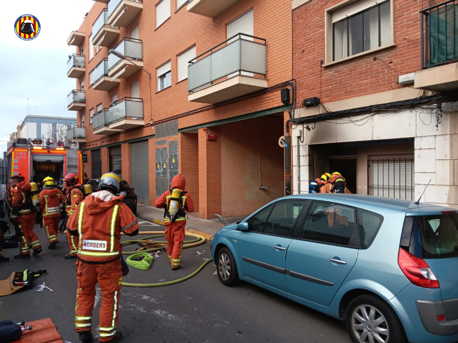 Los bomberos trabajando en la extinción del incendio de una vivienda en Burjassot (Valencia)