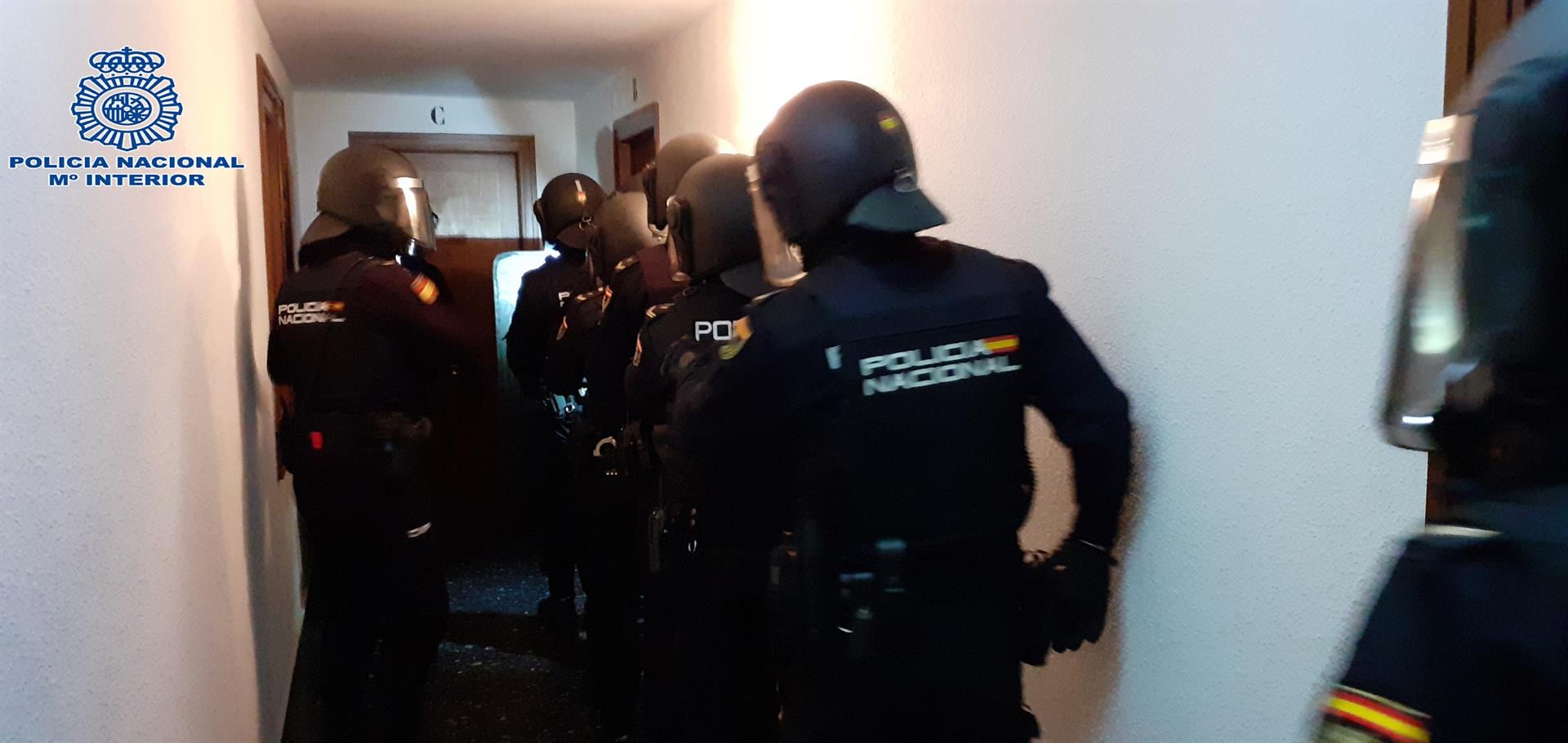 Agentes de la Policía Nacional en el momento de entrar a un domicilio donde se vendía cocaína