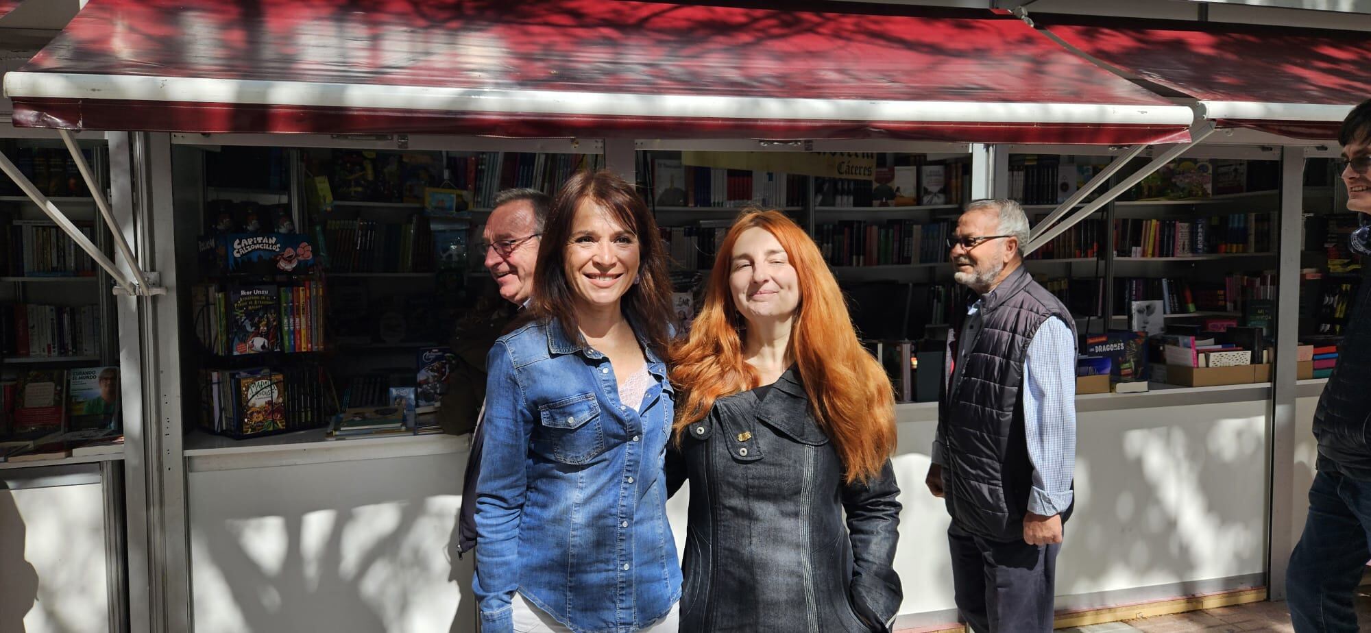 Las socialistas Belén Fernández y Fernanda Valdés, frente a las casetas de la Feria del Libro de Cáceres