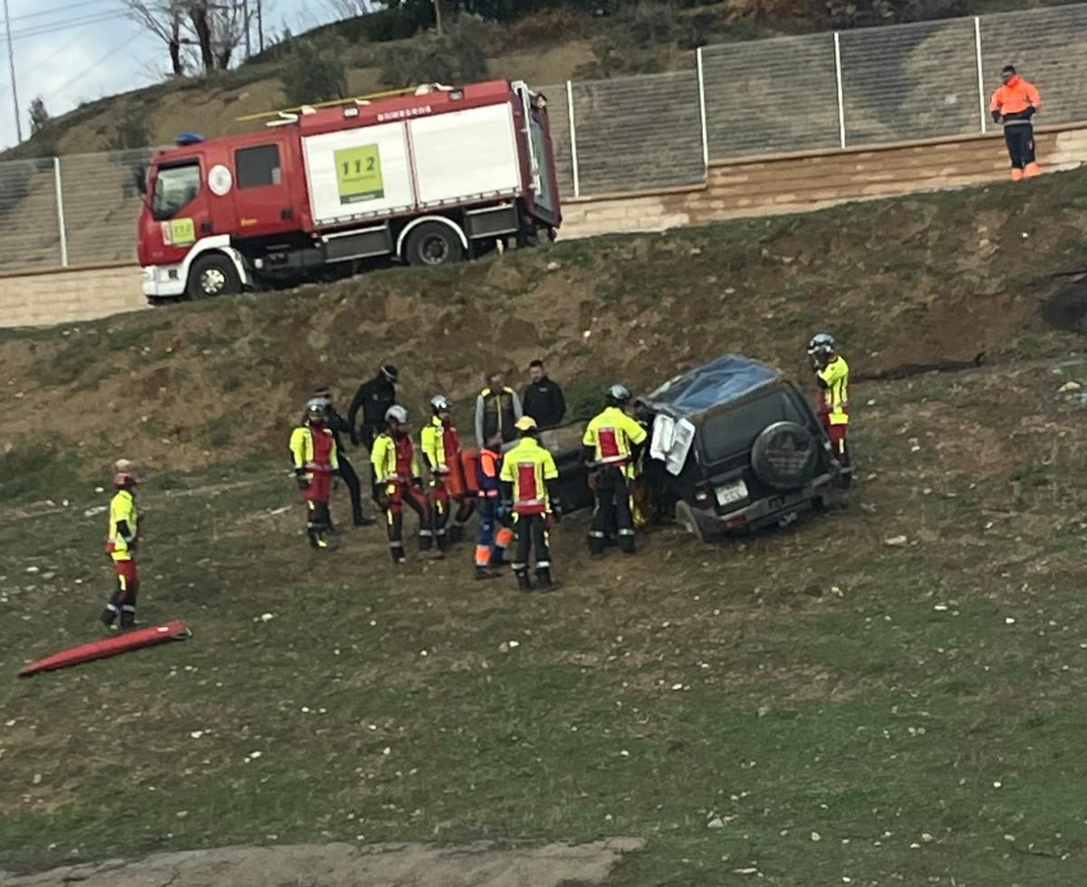 Bomberos y sanitarios atienden al conductor del vehículo.