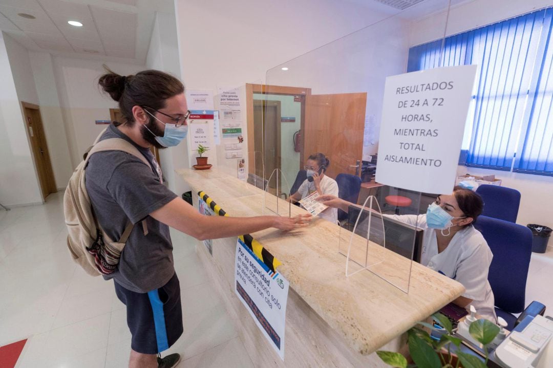  Una enfermera entrega la documentación a un hombre para hacerse la prueba de PCR este martes, en el consultorio del barrio del Progreso de Murcia. 