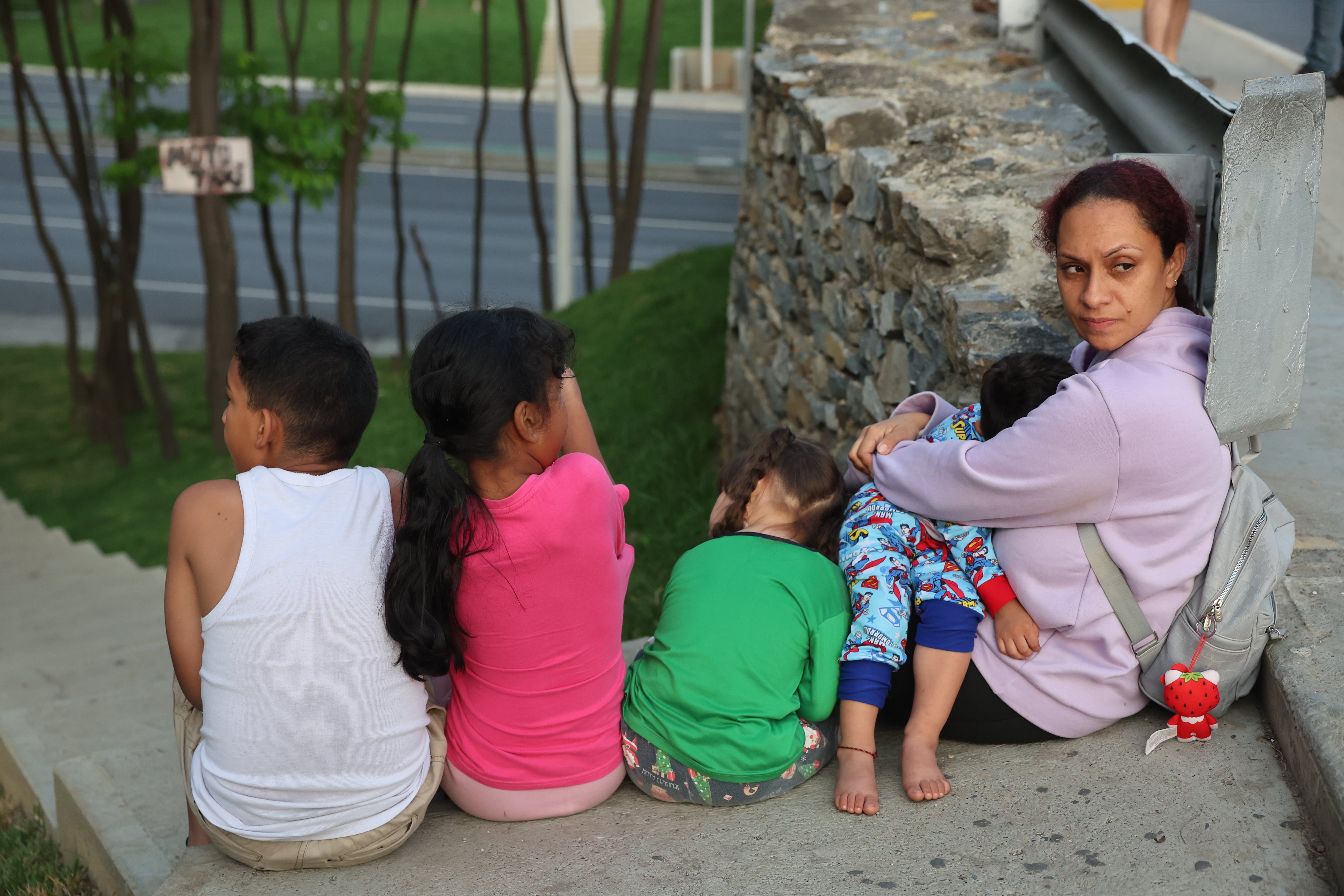 CARACAS (VENEZUELA), 03/01/2026.- Una mujer con sus hijos tras salir de Fuerte Tiuna -que alberga la sede del Ministerio de Defensa-, debido a las detonaciones y explosiones en la madrugada de este sábado en Caracas, en unos momentos en que Venezuela ha denunciado "amenazas" del Gobierno del presidente de Estados Unidos, Donald Trump, por el despliegue militar en el Caribe y las advertencias de ataques terrestres. EFE/Miguel Gutiérrez