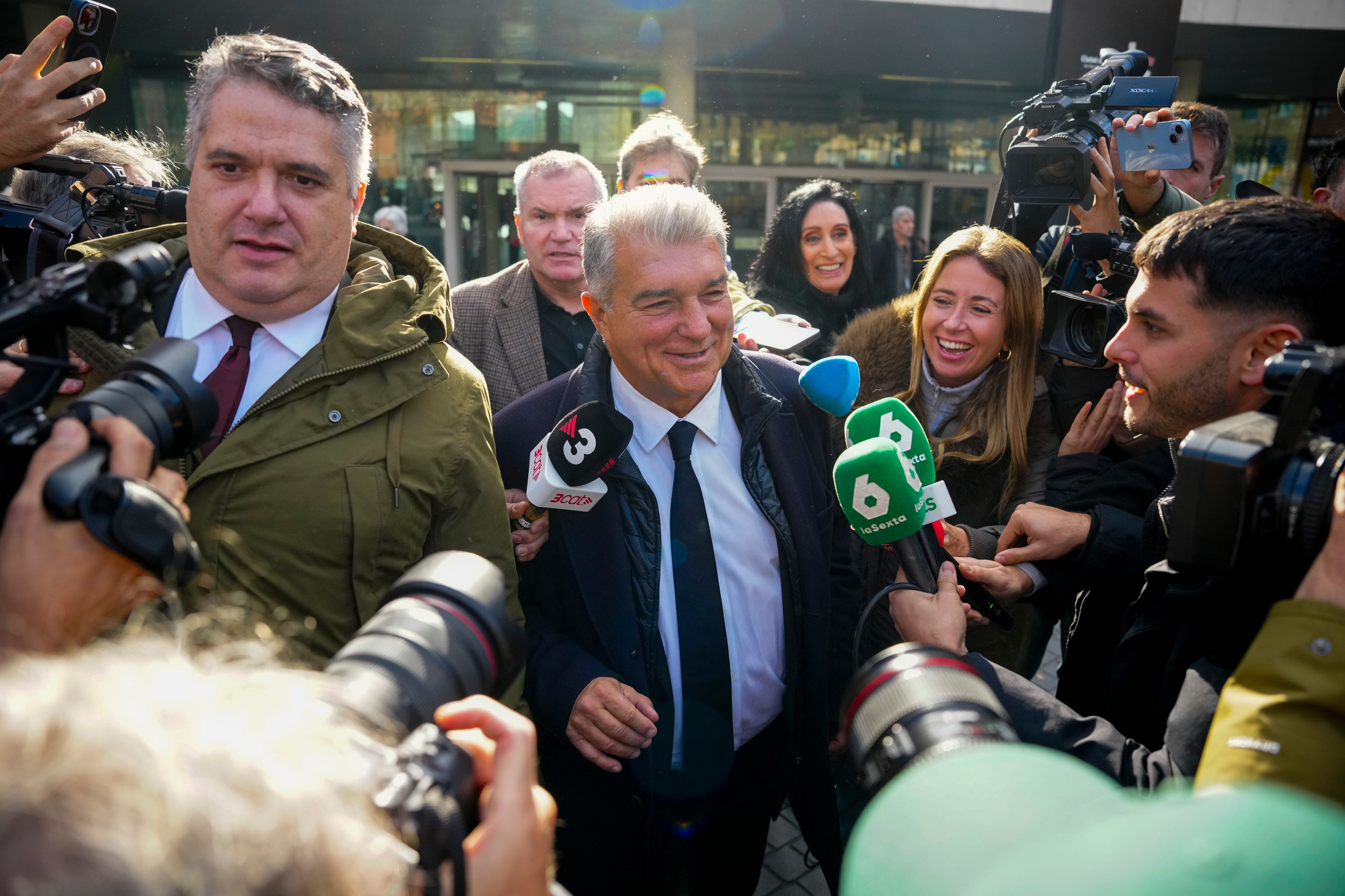 BARCELONA, 12/12/2025.- El presidente del Barcelona, Joan Laporta (c), rodeado de periodistas, a su salida este viernes del Juzgado de instrucción número 1 de Barcelona tras declarar como testigo en el marco de la instrucción del caso Negreira, que investiga el pago de más de 7 millones de euros por parte del club a este entre 2001 y 2018 cuando era vicepresidente del Comité Técnico de Árbitros. EFE/ Alejandro García