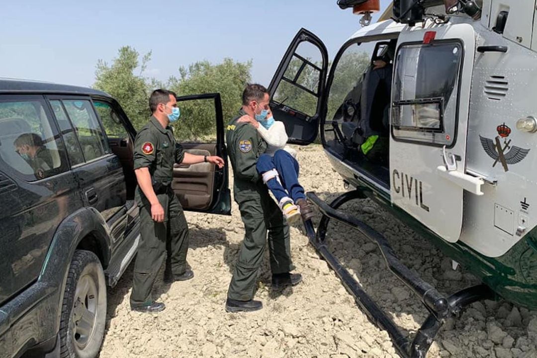 Dos guardias civiles socorren a la mujer accidentada.