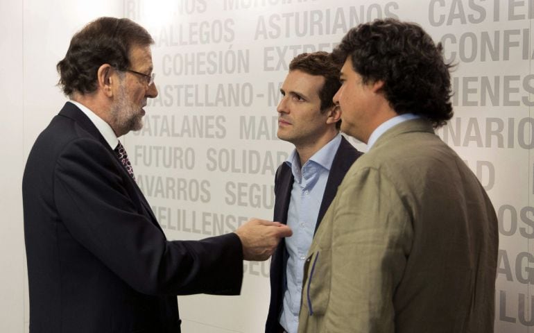 Fotografía facilitada por el PP de su presidente y titular del Gobierno, Mariano Rajoy, que conversa con el que será vicesecretario de Comunicación, Pablo Casado (2d), y el futuro director de campaña para las elecciones generales, Jorge Moragas (d), tras 