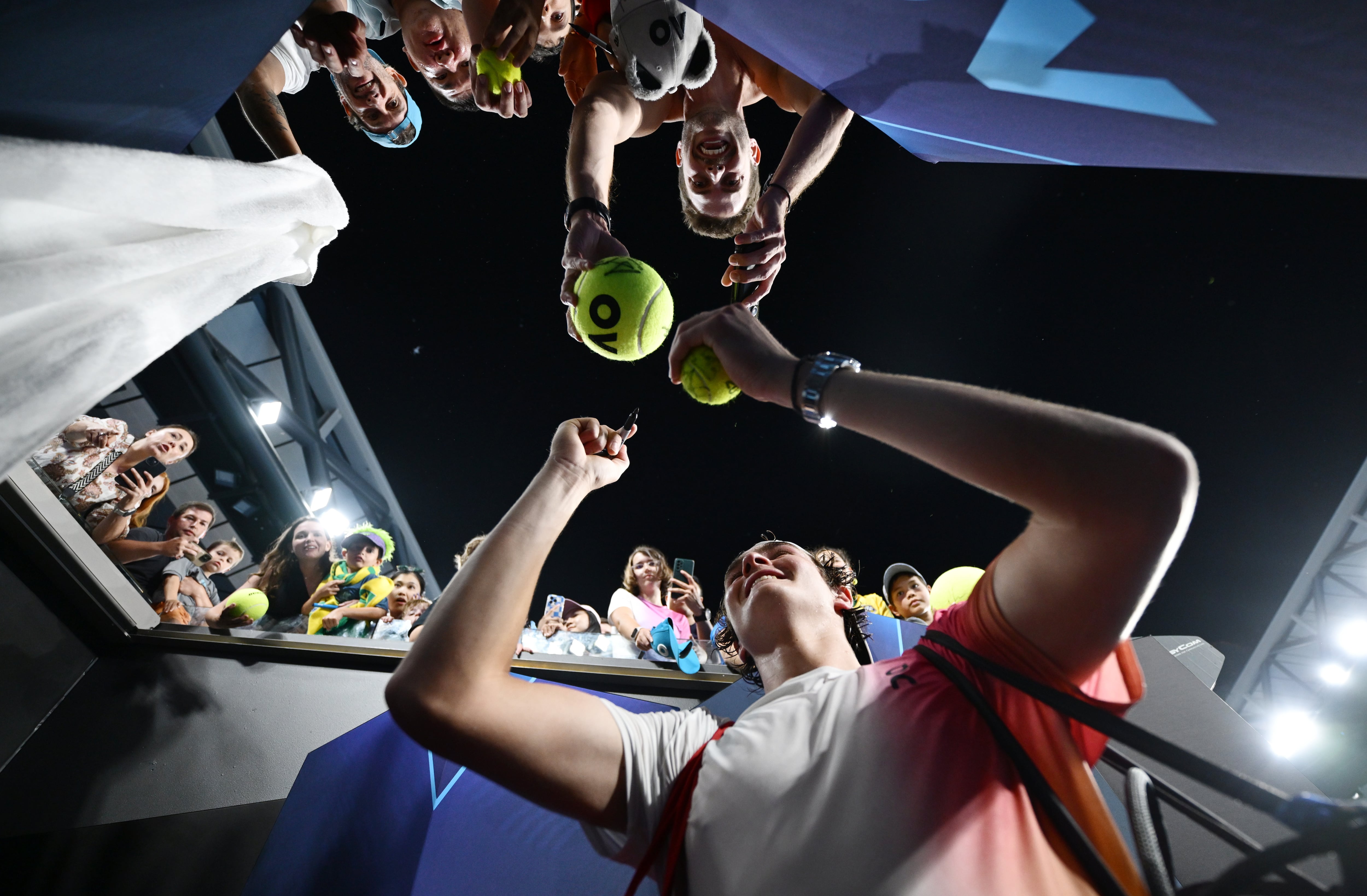 Joao Fonseca firma a unos aficionados tras vencer a Rublev en el Open de Australia